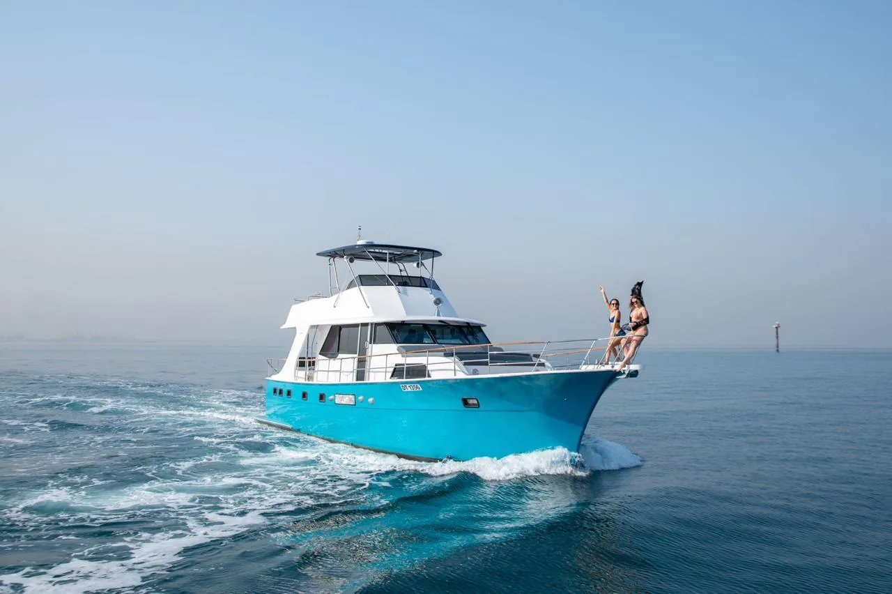 A yacht cruising the Arabian Gulf off Dubai with guests on the bow